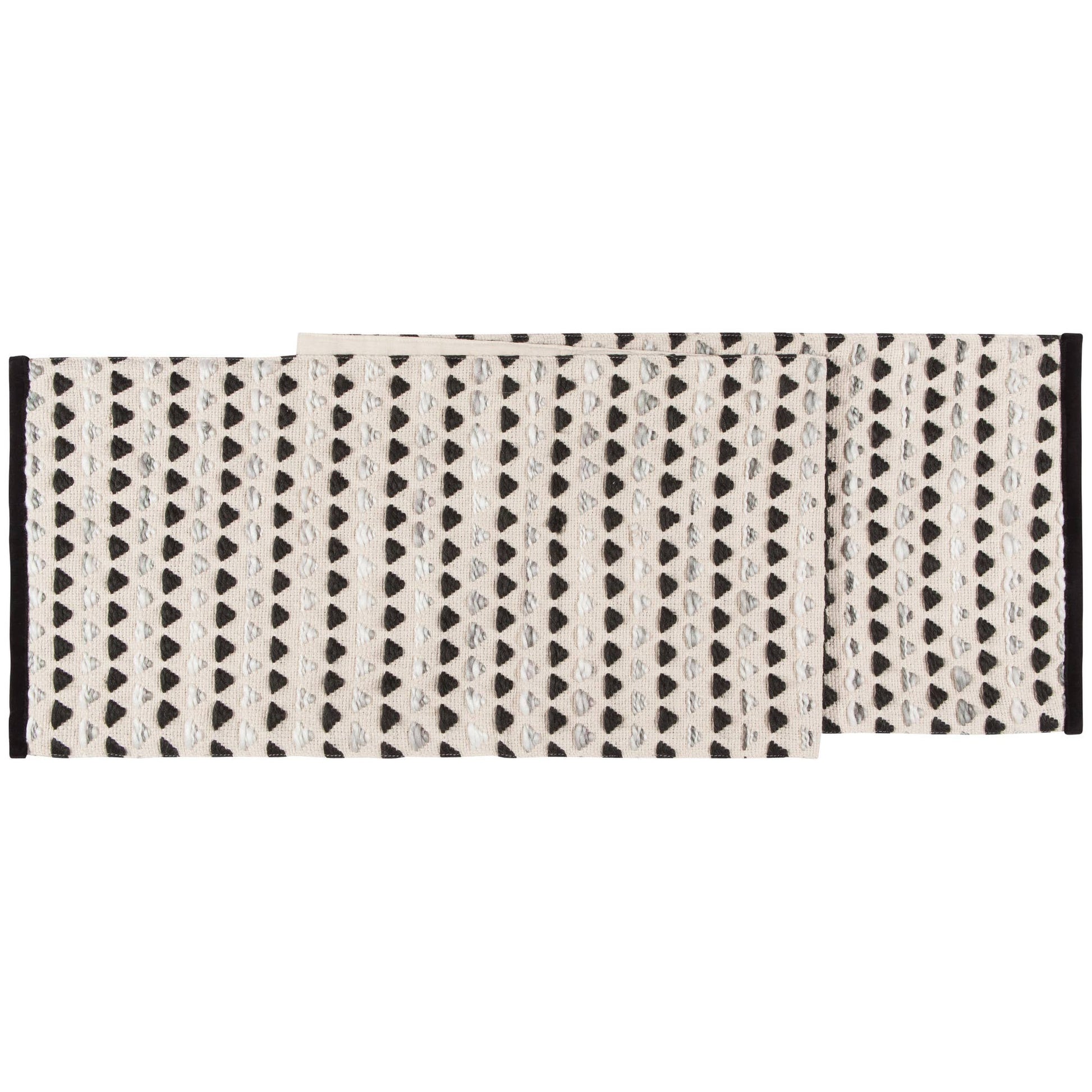 A beige and black woven table runner with a geometric pattern and velvet trim.